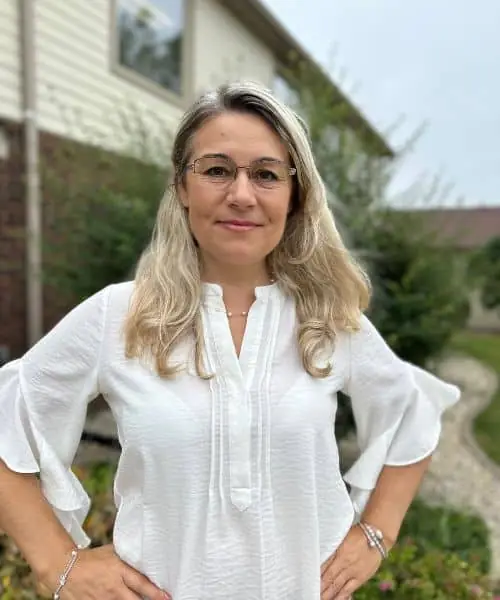 Ava Palek, owner of Touch of Europe Cleaning, standing outdoors in a white blouse