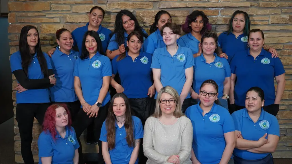 The Touch of Europe Cleaning staff in blue polos in front of a stone wall